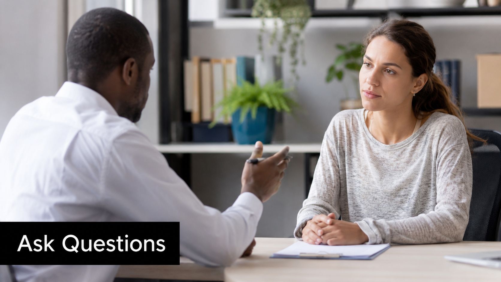A professional man conducting a job interview with a female candidate in a modern office setting.